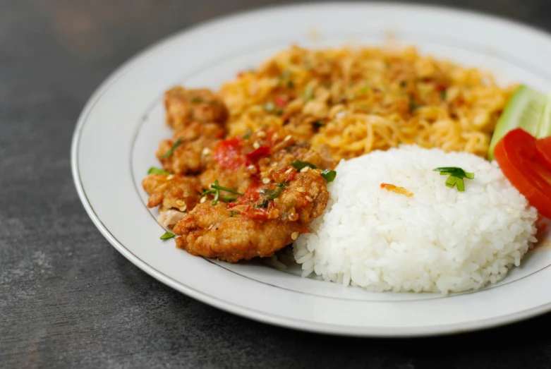 a plate of rice and meat with garnish and vegetables