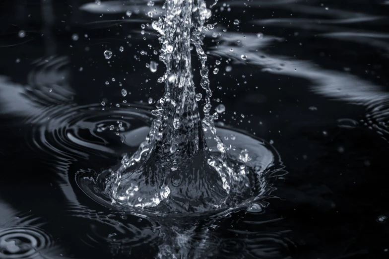 the water splashing from a vase in the middle of the dark water