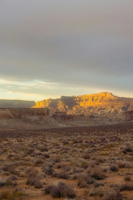 the sun sets behind a hill and desert area