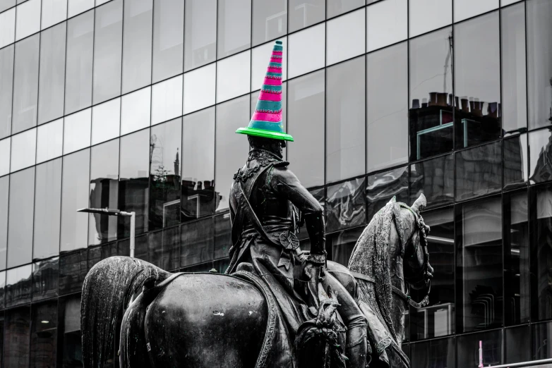 black statue with multicolored hat on the top of it