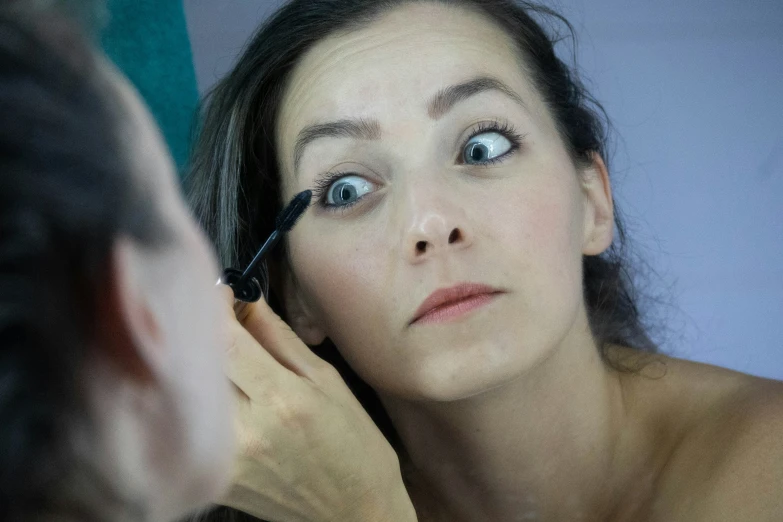 a  using a comb and mascara brush