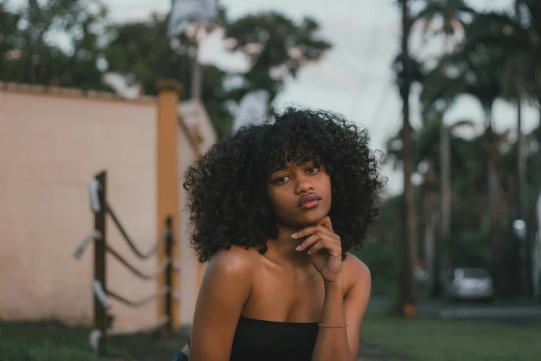 a girl with natural hair and dress poses for a po