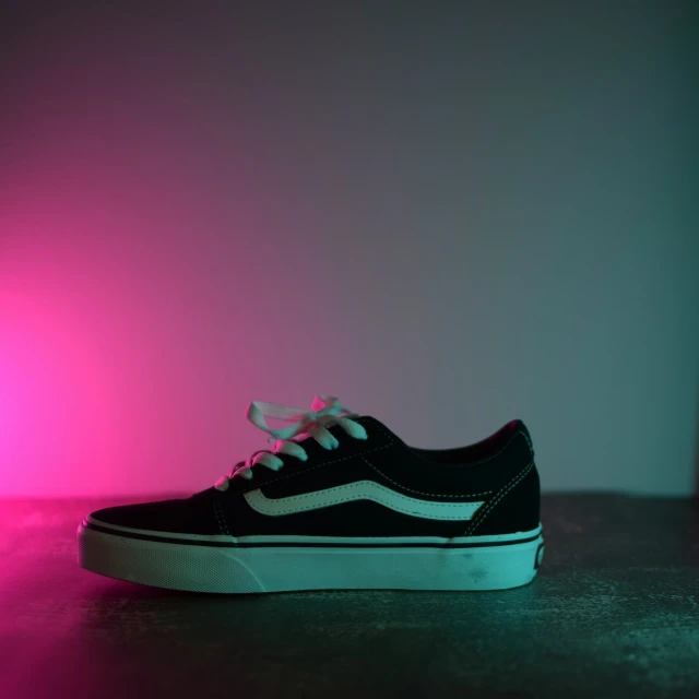 a black and white sneaker with pink lights