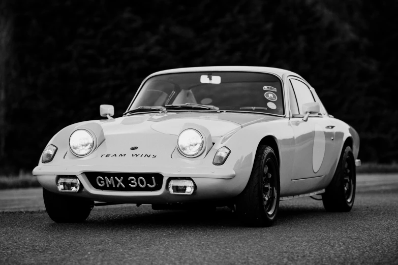 an old white car that is on the street