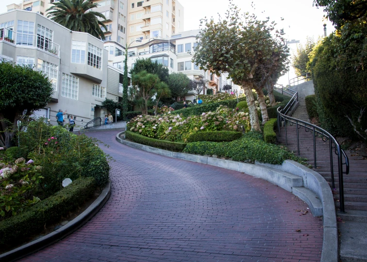 a garden and winding brick path are on a street corner