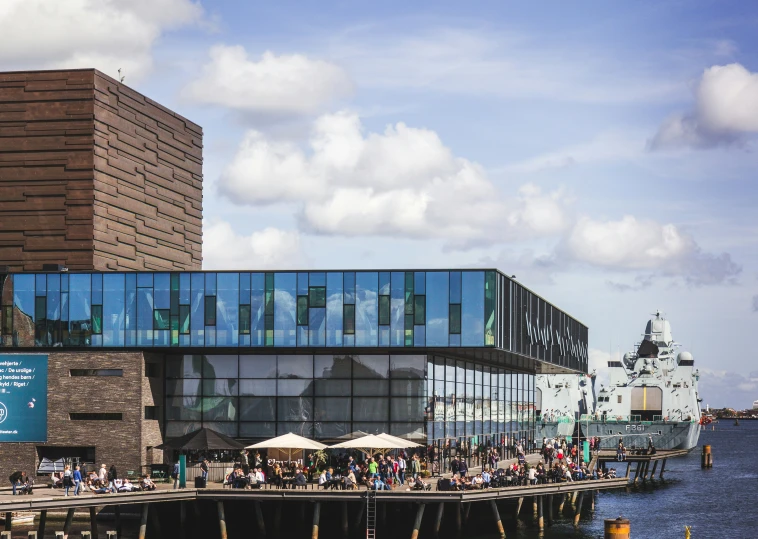 people are walking across a bridge near a harbor