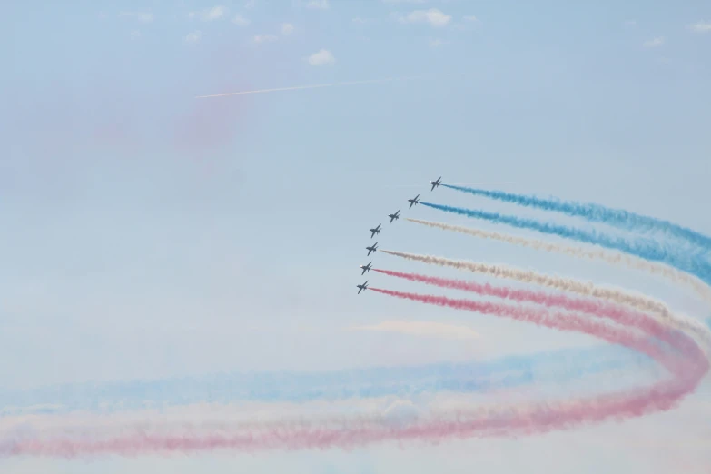 six airplanes in formation with colorful smoke behind them