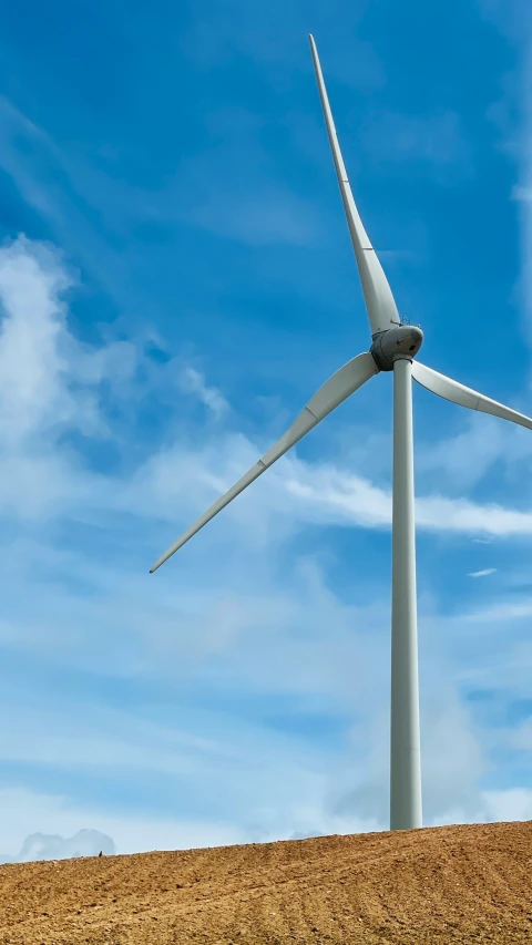 a wind turbine sitting on the side of a hill