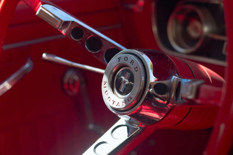 the steering wheel on a red car with chrome spokes