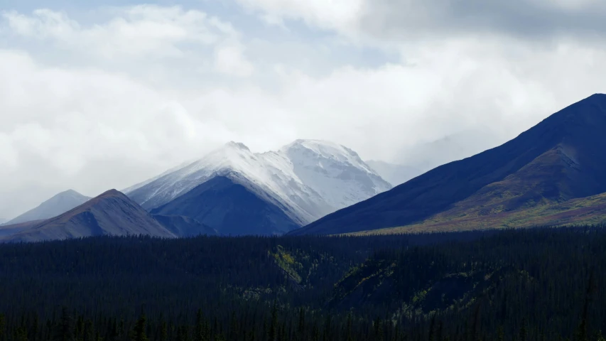 a mountain scene with a snowy mountain in the background