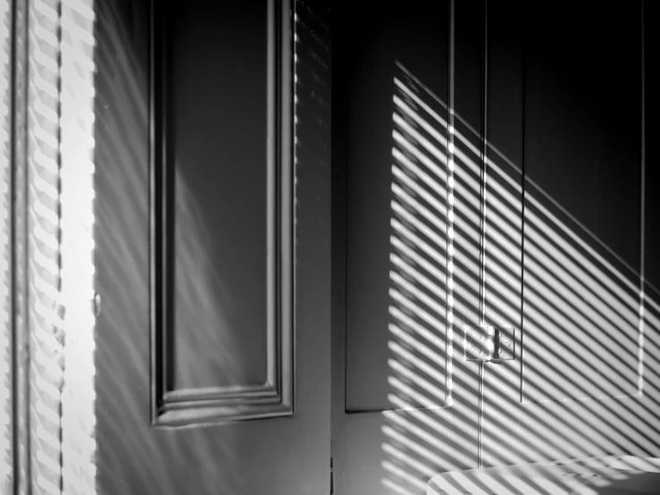 the shadows of a wall and cupboard with the light coming in