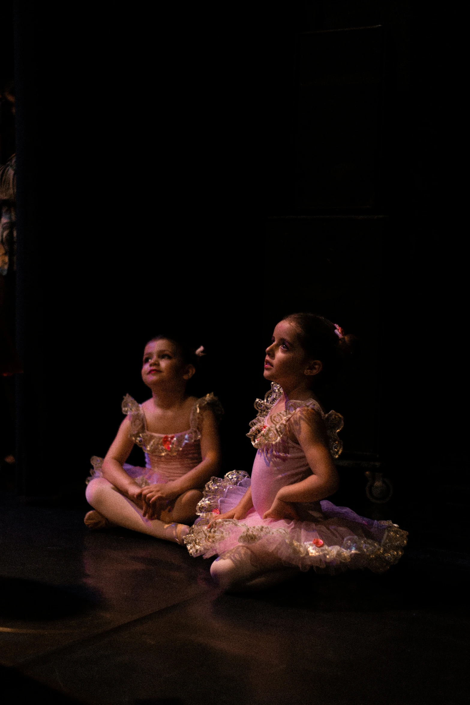 two girls sitting on the floor talking together