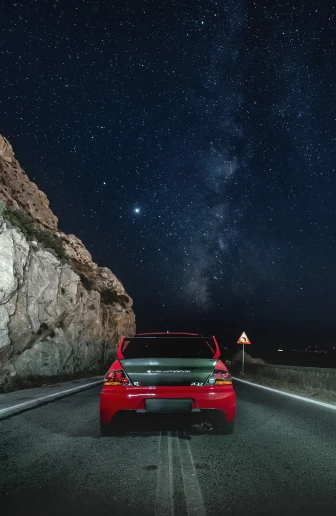 a car on a highway under a starr filled sky