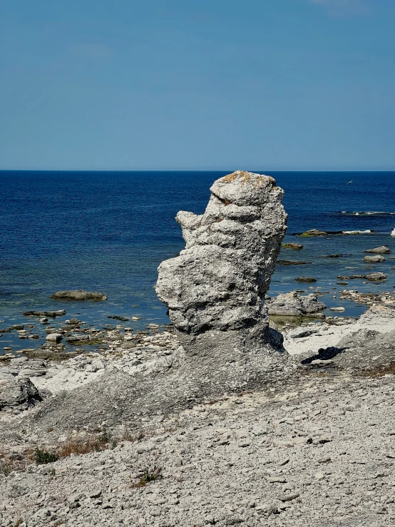 rock formations in the sand near a body of water