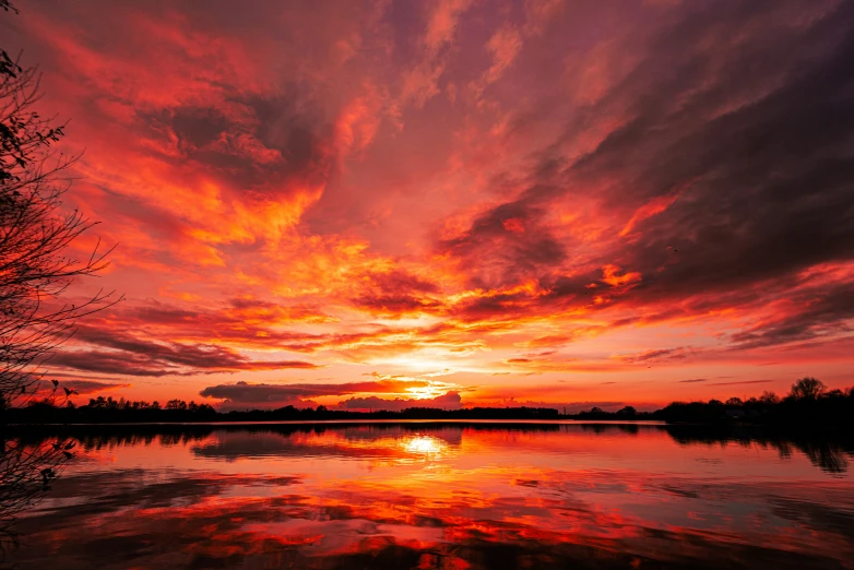 sunset reflecting into a still lake as it begins to redish