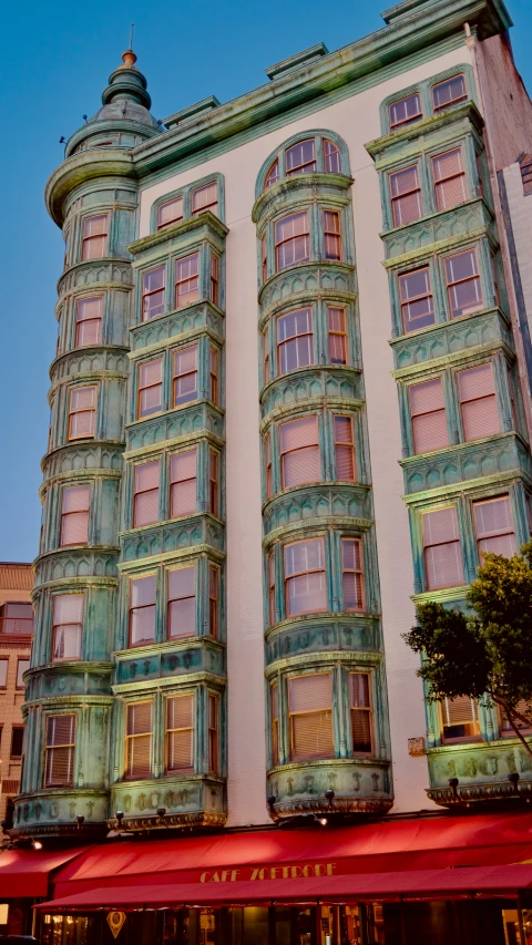 the large building has many windows and has red awnings