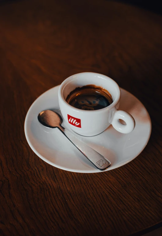 a cup of coffee sits on the saucer with a spoon