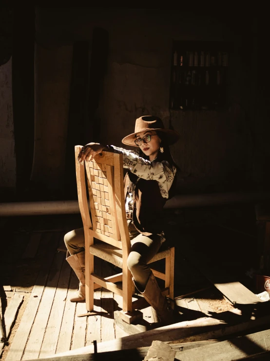 a little boy sitting in a wooden chair