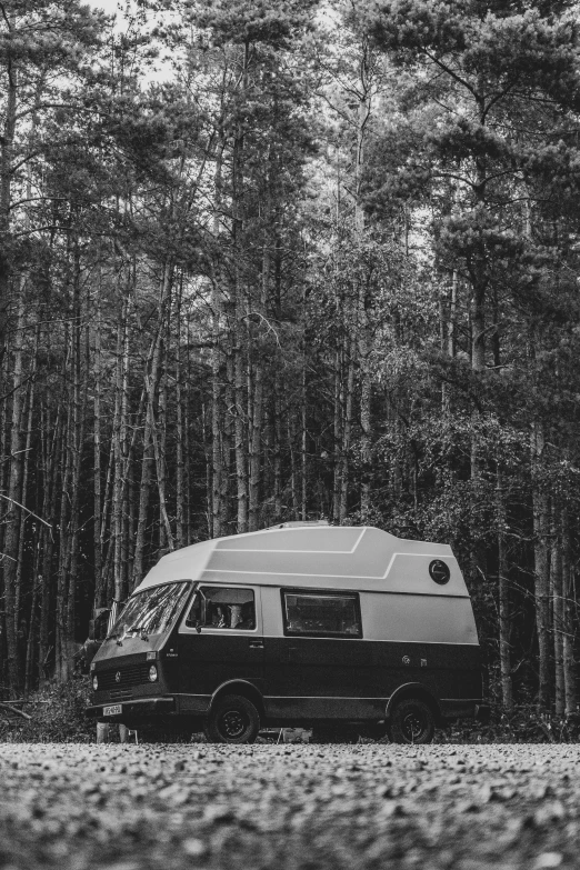 a black and white image of a car camping in the woods