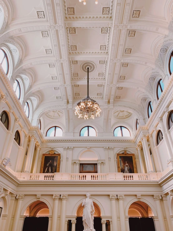 the interior of an ornate building that has a white ceiling with arched windows