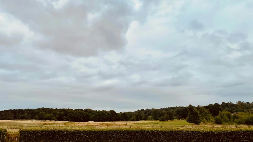 a grassy field in the distance on a cloudy day