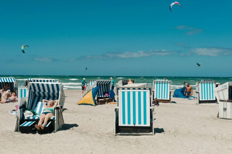 many people are relaxing in chairs on the beach