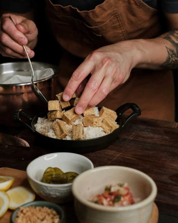 a man is making food at a table with some other bowls