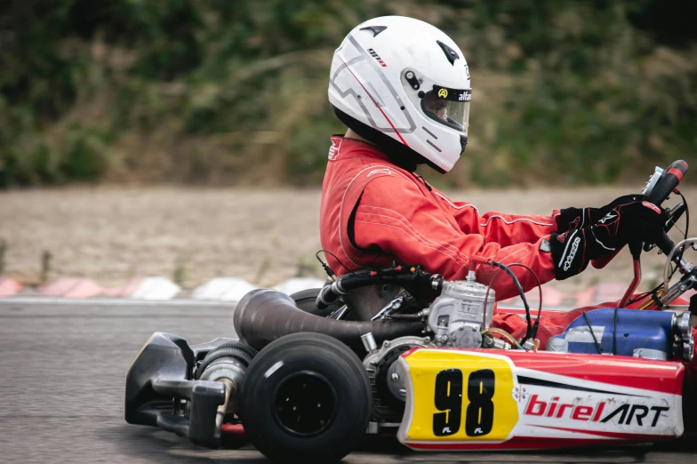 the small boy has a helmet on while riding his small car