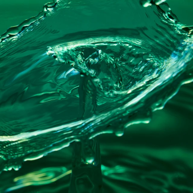 green water that appears to be falling off of the surface