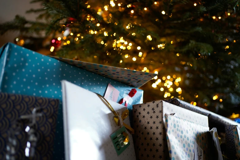 an open christmas gift box in front of a christmas tree