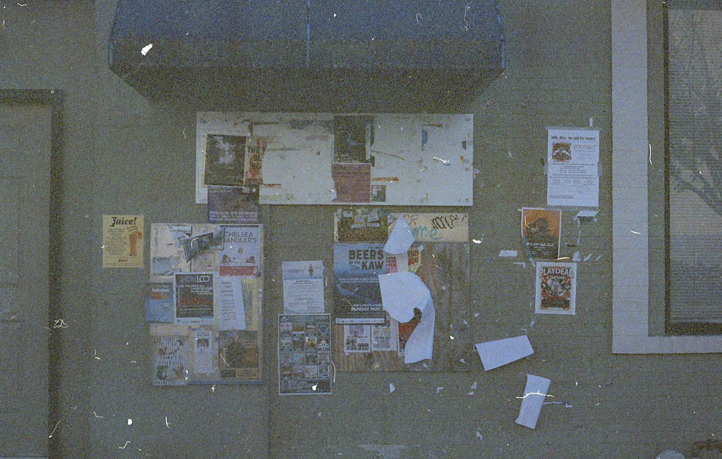 a woman is looking at a wall covered in advertits