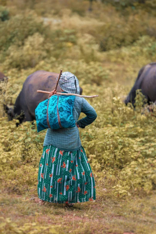 the woman in the field has a stick on her head