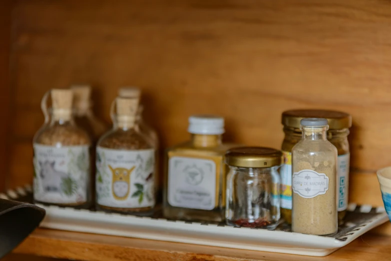 spice jars are sitting on the shelf with spoons