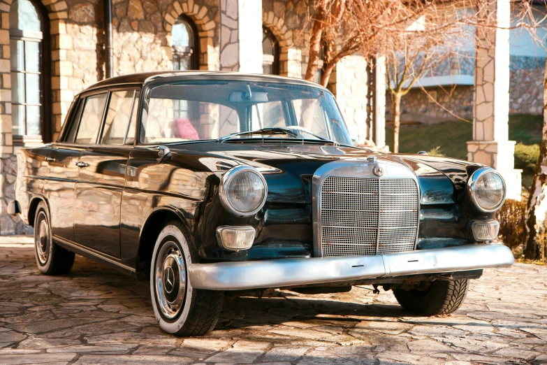 an old black car parked on the side of a road