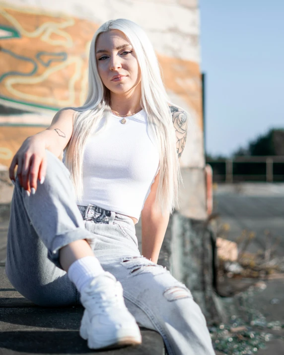 a woman is sitting on the concrete with her feet on the ground