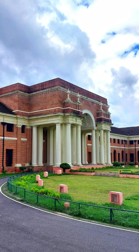 a very large brick building in the middle of the grass