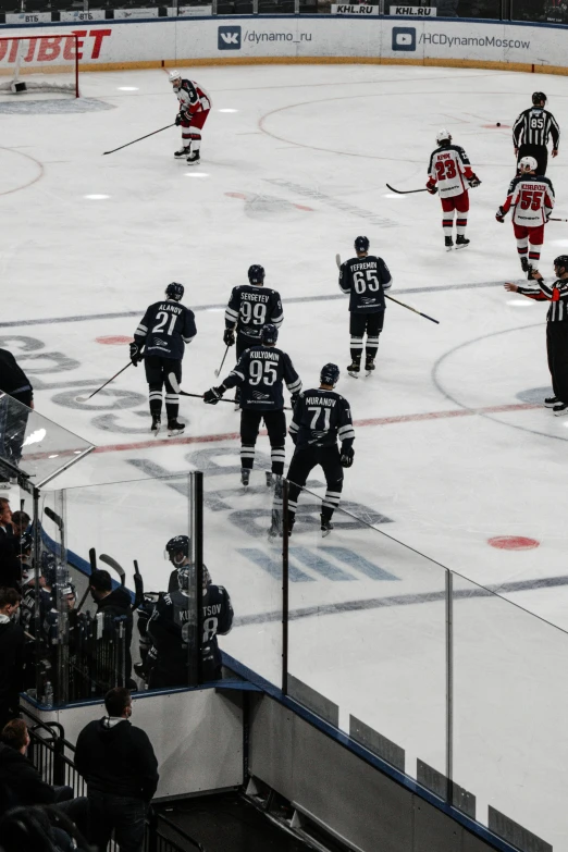 a group of young men playing hockey on an ice rink