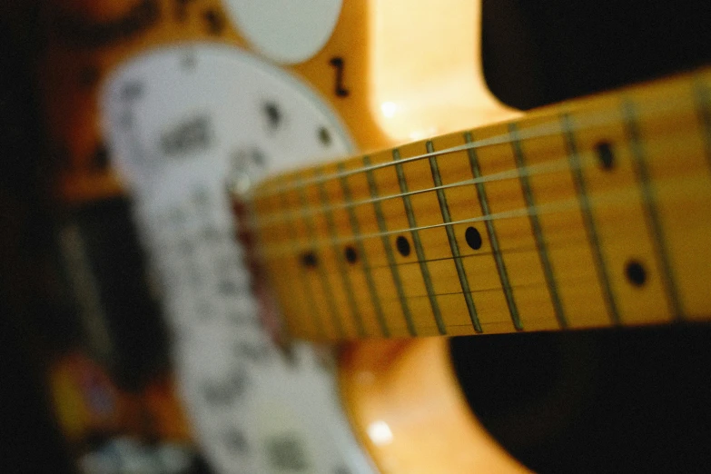 an electric guitar sits with a paper sheet that looks like an image of music equipment