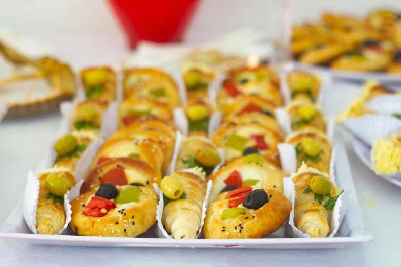 many rolls are sitting on white plates on a table