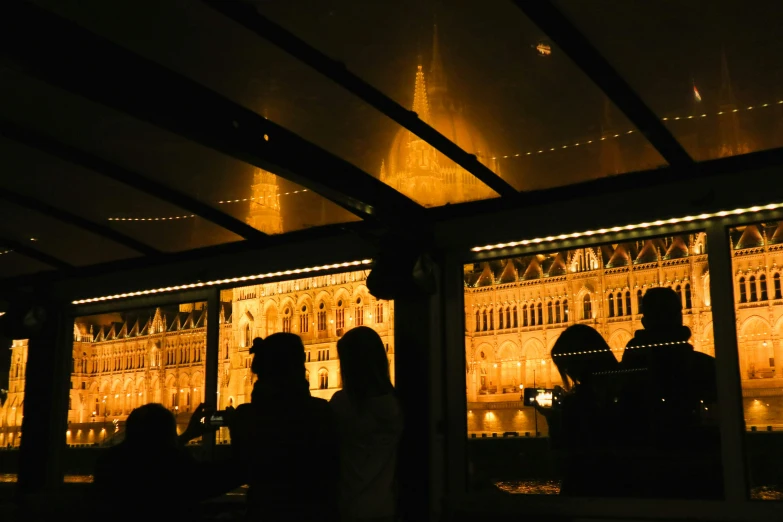 people are standing at a window in front of an ornate building