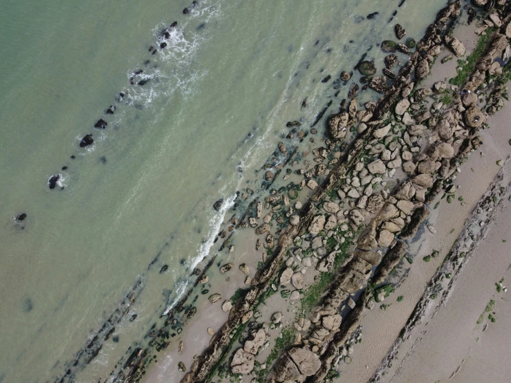 people are wading in the water, by a beach shore