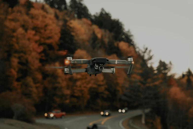 a camera flies in the air over a rural road