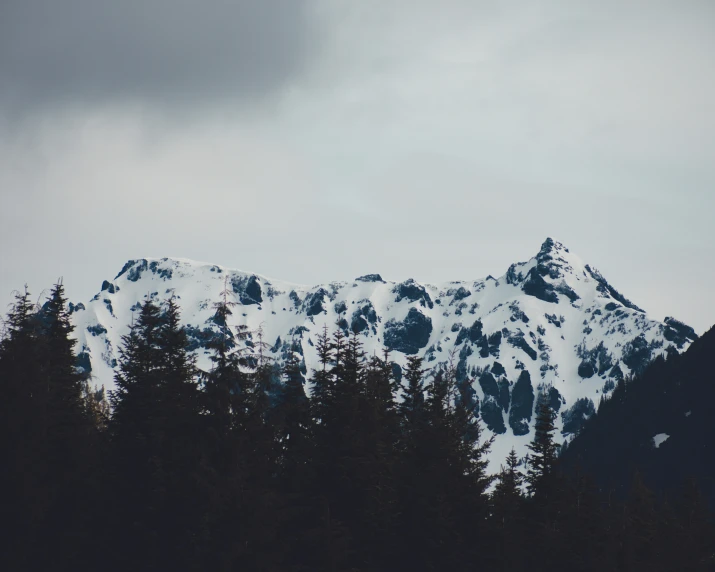 mountains covered in snow as the sky is grey