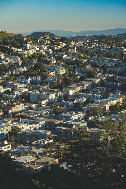 a group of large, colorful buildings sits below a mountain range