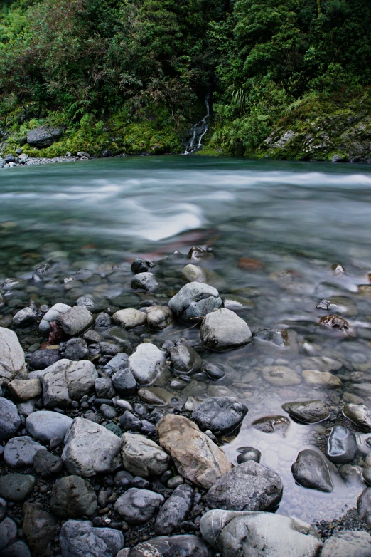 there is water coming from behind rocks in the water