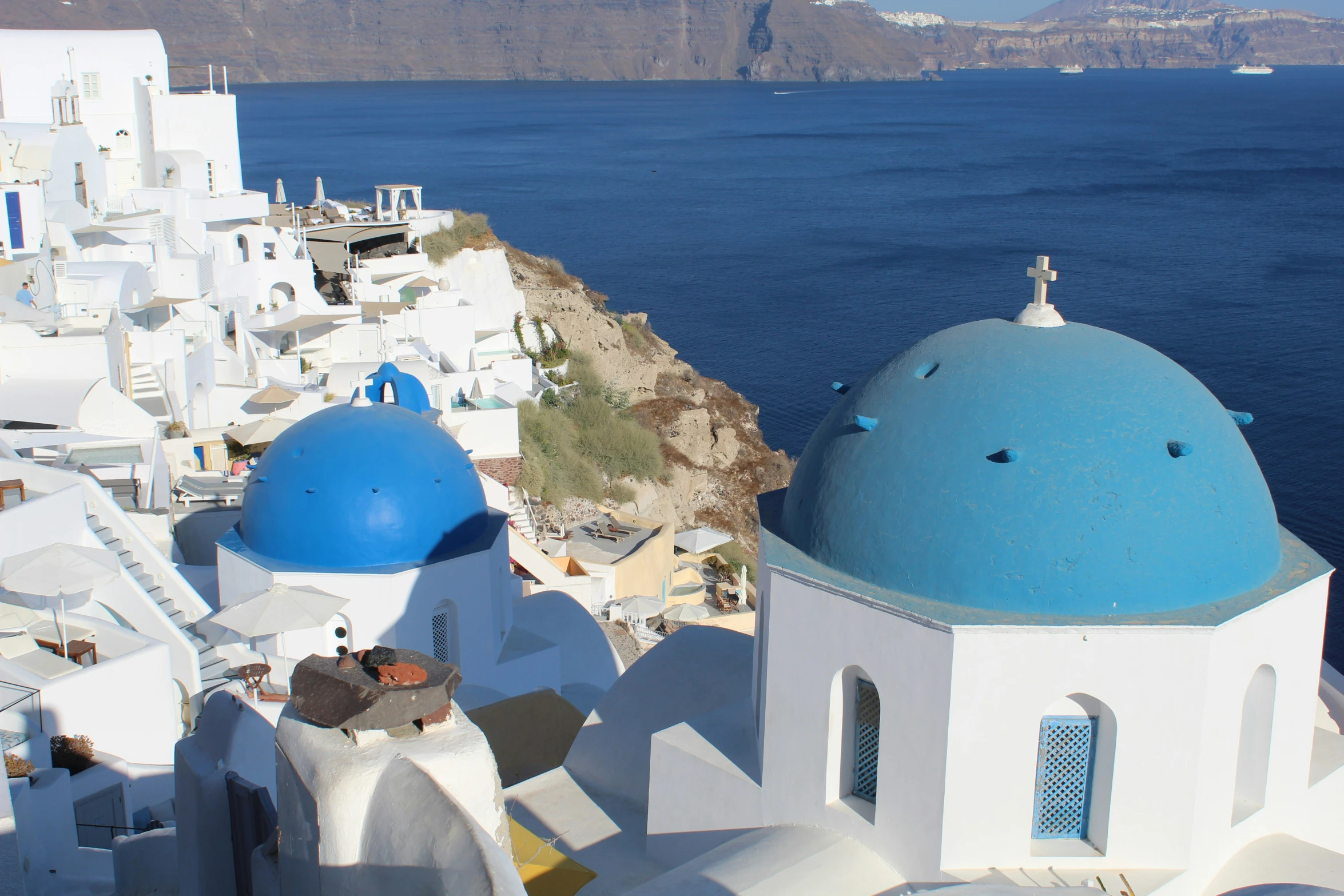 white and blue buildings are overlooking the ocean