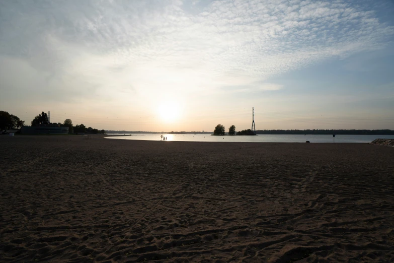 an empty beach with a sunset reflecting on the water