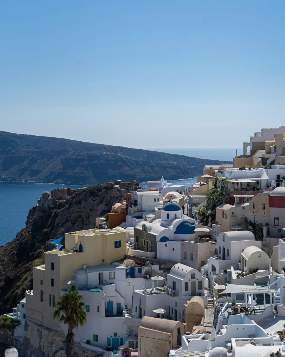 a bunch of houses are on a hill by the water