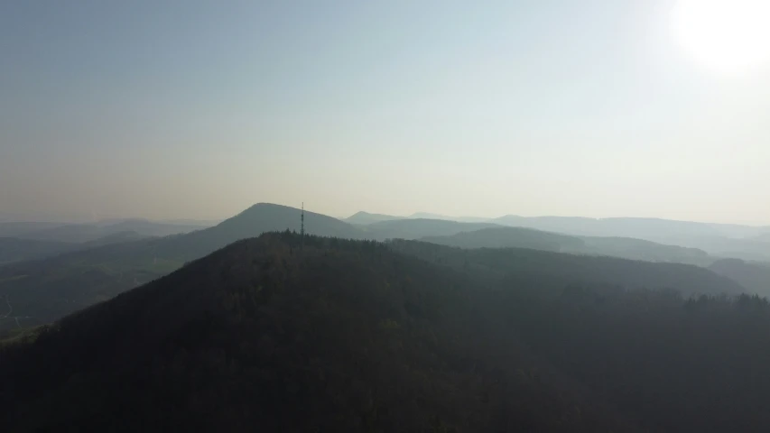 the view of hills with mountains in the distance