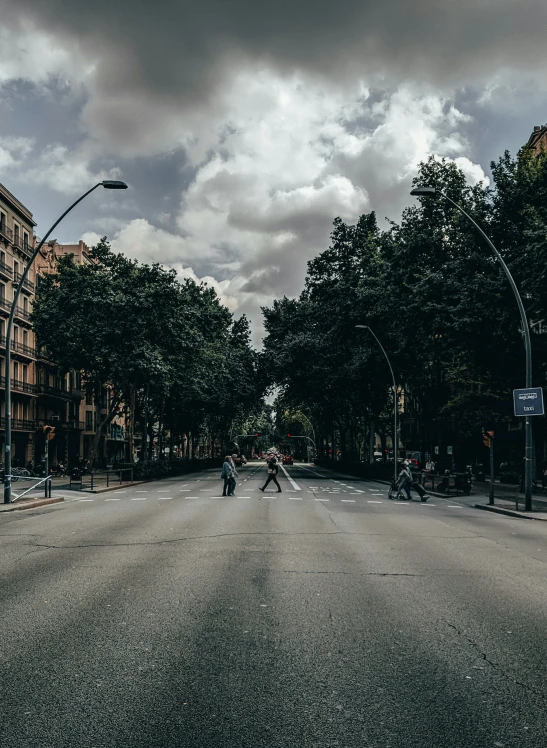 two people crossing the street in front of an apartment building